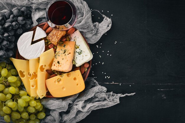 Assortiment kazen een fles wijn, honing, noten en kruiden op een houten tafel Bovenaanzicht Vrije ruimte voor tekst