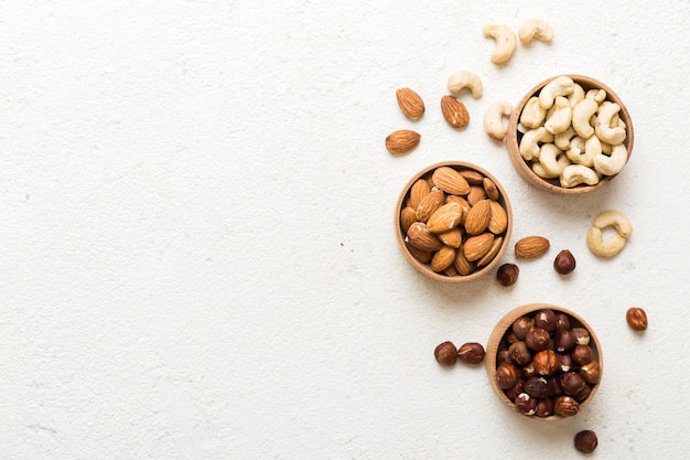 Assortiment noten in een houten schaal op een gekleurde tafel Cashew hazelnoten walnoten amandelen mengsel van noten Bovenbeeld met kopieerruimte