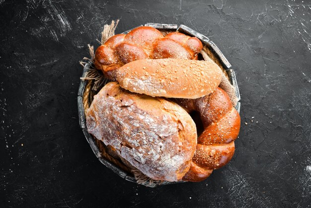 Assortiment van brood en bakken op een zwarte stenen achtergrond Bovenaanzicht Vrije ruimte voor uw tekst