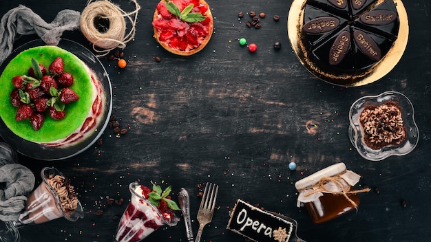 Assortiment van desserts Op een zwarte houten achtergrond Bovenaanzicht Kopieer de ruimte