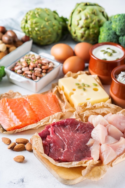 Assortiment van gezonde eiwitbron en bodybuilding voeding Vlees rundvlees zalm kipfilet eieren zuivelproducten kaas yoghurt bonen artisjokken broccoli noten havermeel