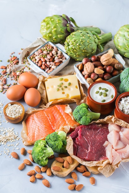 Assortiment van gezonde eiwitbron en bodybuilding voeding Vlees rundvlees zalm kipfilet eieren zuivelproducten kaas yoghurt bonen artisjokken broccoli noten havermeel