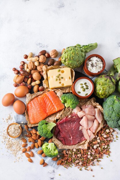 Assortiment van gezonde eiwitbron en bodybuilding voedsel vlees rundvlees zalm kip borst eieren zuivelproducten kaas yoghurt bonen artisjokken broccoli noten haver maaltijd kopie ruimte achtergrond bovenaanzicht