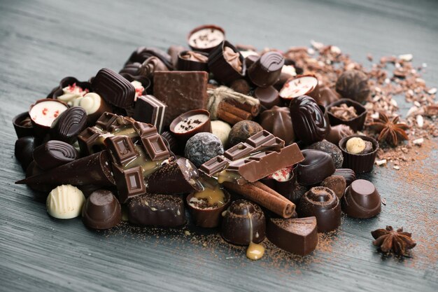 Assortiment van lekkere chocolade snoepjes en kaneel op houten tafel achtergrond