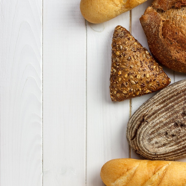 Assortiment van vers brood op een witte houten achtergrond bovenaanzicht met kopie ruimte