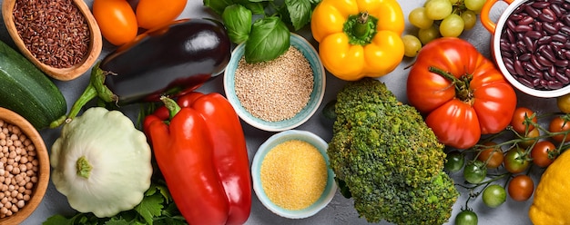 Assortiment van vers fruit en biologische veelkleurige regenbooggroenten op grijze betonnen ondergrond. Eten koken en gezonde schone voedselachtergrond en mock-up.