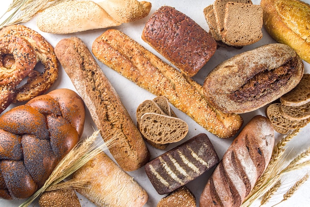 Assortiment van verschillende heerlijk vers gebakken brood, op witte ondergrond bovenaanzicht kopie ruimte