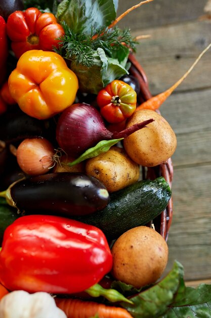 Assortiment van verse groenten in een mand, bio-gezond, biologisch voedsel op houten achtergrond, landelijke marktstijl, tuinproducten, vegetarisch dieetvoedsel, schoon eten.