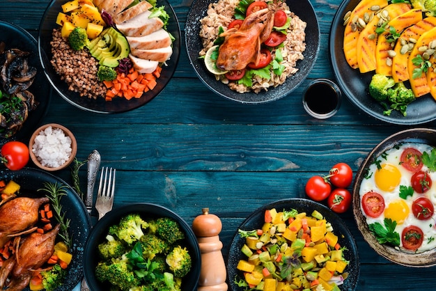 Assortiment van voedsel Salade avocado kwartel champignons pompoen Op een blauwe houten achtergrond Bovenaanzicht Vrije ruimte voor uw tekst