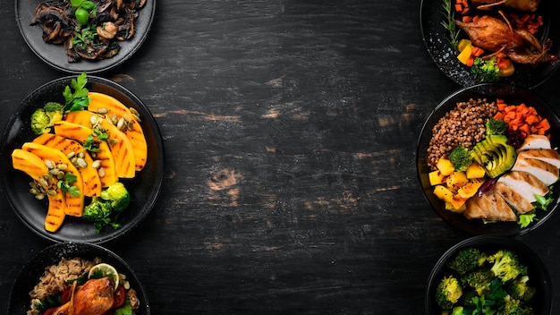 Assortiment van voedsel salade avocado kwartel champignons pompoen op een zwarte achtergrond bovenaanzicht vrije ruimte voor uw tekst