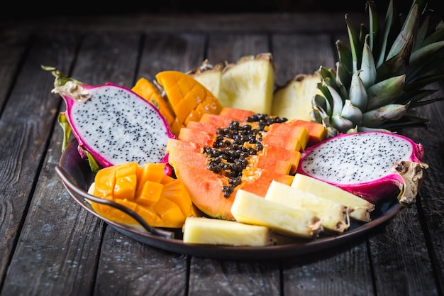 Assortimentsset voor het snijden van tropisch fruit. Papaya Pijnboom Appel Mango Sapodilla Draak op het dienblad