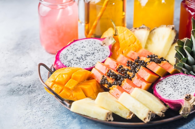 Assortimentsset voor het snijden van tropisch fruit. papaya pijnboom appel mango sapodilla draak op het dienblad