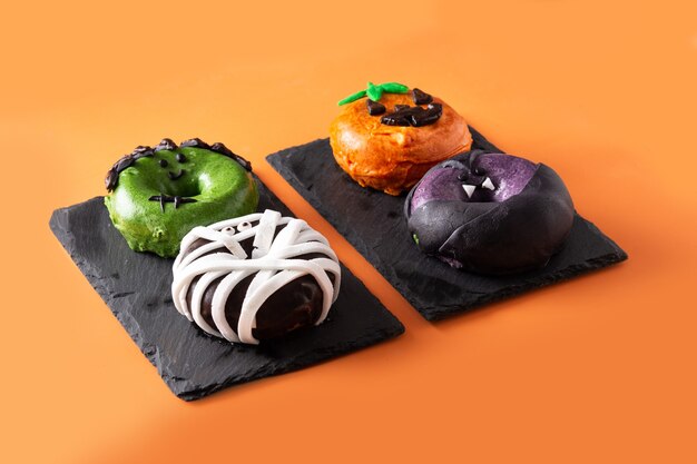 Assortmen of Halloween donuts on orange background