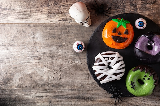 Assortmen of Halloween donuts on wooden table