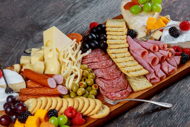 Assortment of appetizers: different sorts of cheese, crackers, grapes, nuts,