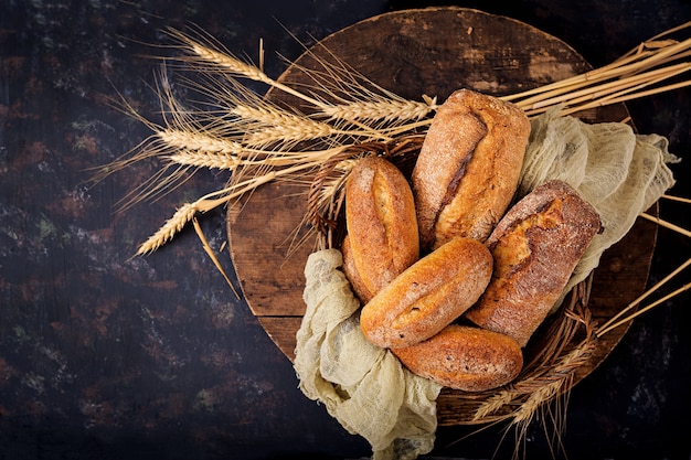 Assortment of baked bread and bun on a wooden background. Top view. Flat lay