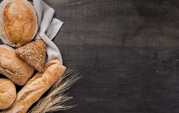 Assortment of baked bread on cloth with wheat