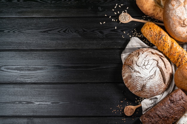 Assortment of baked bread on wooden table background