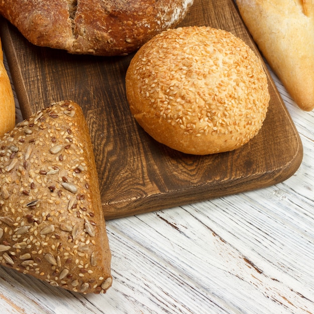 Assortment of baked bread on wooden table. top view with copy space