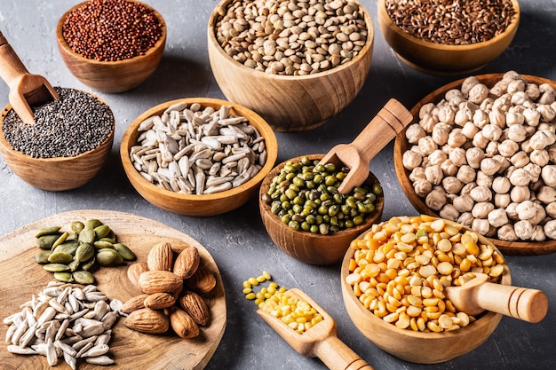 Assortment of beans, seeds, legumes on grey concrete background.