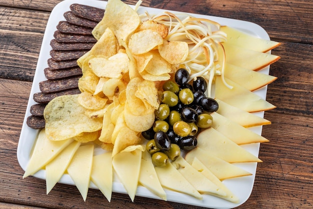 Assortment of beer snacks dried meat smoked cheese and sausage on wooden background