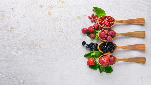 Assortment of berries Raspberries blackberries strawberries cranberries On a wooden background Top view Free space for text