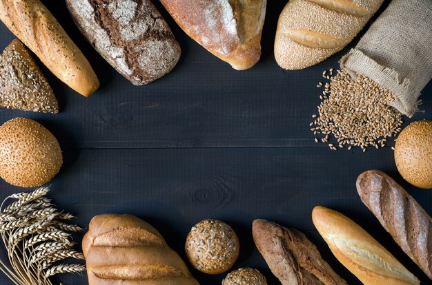 Assortimento di pane con chicchi di grano su sfondo scuro. spazio libero per il tuo testo. vista dall'alto.