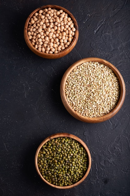 Assortment of cereals, legumes, cereals, grains, lentils, chickpeas, peas, beans in wooden bowls