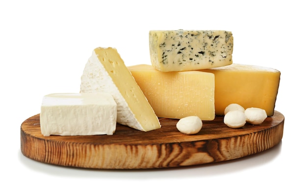 assortment of cheese on wooden board isolated on white