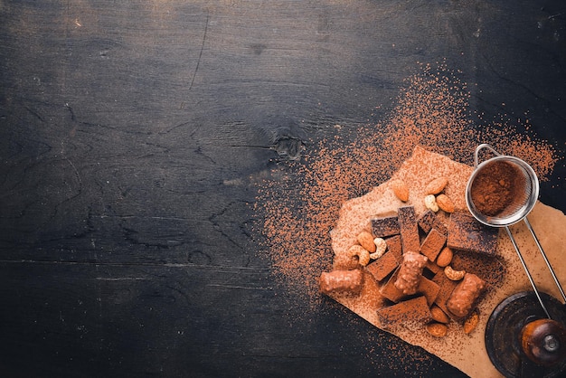 Assortment of chocolates with nuts Black and milk chocolate Wooden on the black surface Top view