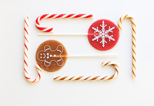 Assortment of Christmas sweets on white background. Candy cane, round lollipop. 