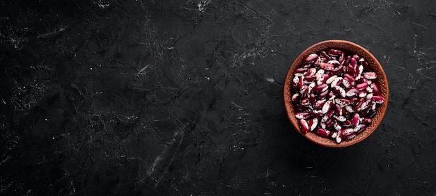 Assortment of colored raw beans On a black stone table Top view Free copy space