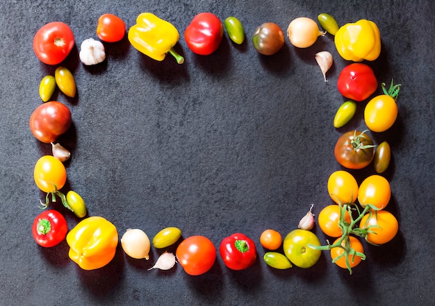 Assortment of colorful fresh vegetables on black surface