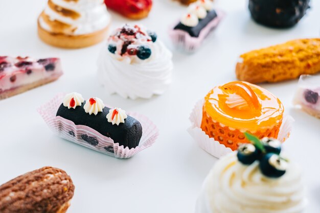 Photo assortment of confectionery, different types of cakes and desserts on the table.