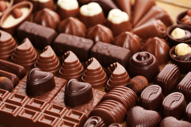 Assortment of delicious chocolate candies background, close up