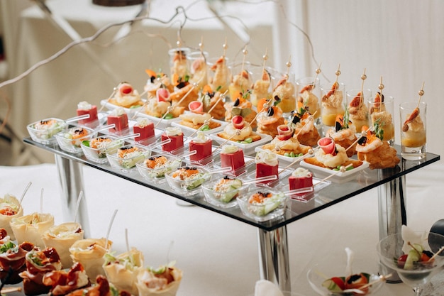 Assortment of delicious snacks on the open buffet festive table in restaurant catering plate