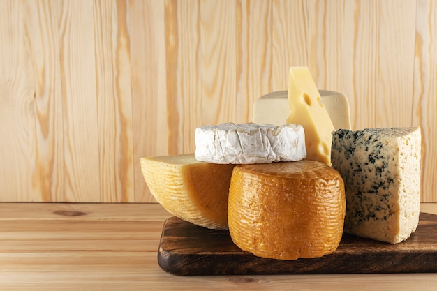 Assortment of different cheese types on wooden table.