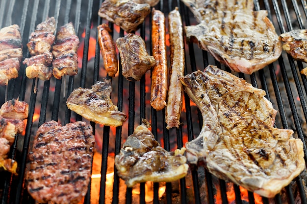 Assortment of different meat grilling on a fire