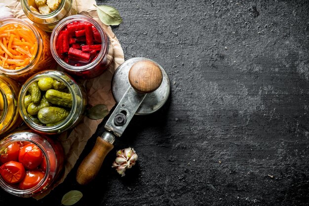 Assortment of different preserved food in glass jars on paper