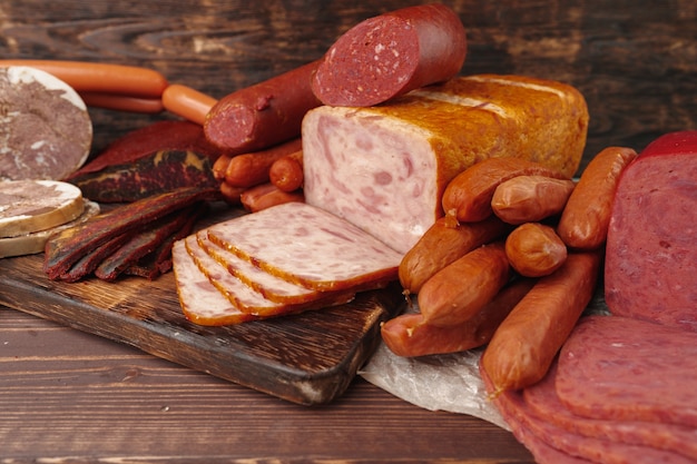 Assortment of different sausages and meat laid out on brown wooden