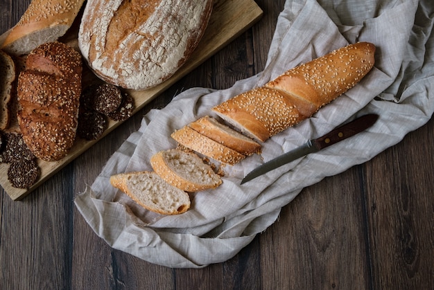 Assortment of different types of bread on a wooden background