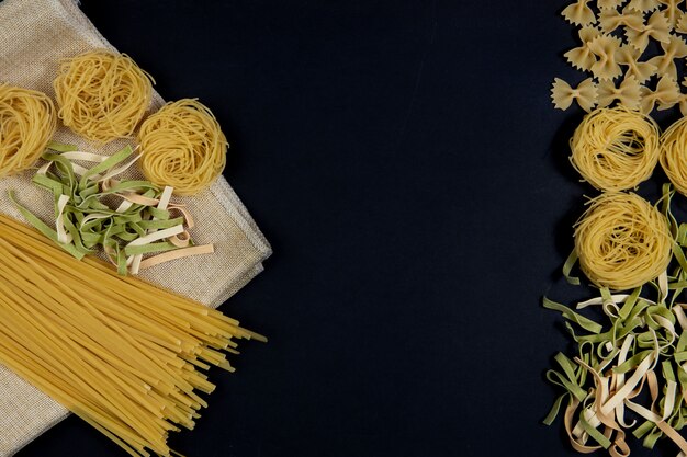 Assortment of different types of pasta on black background