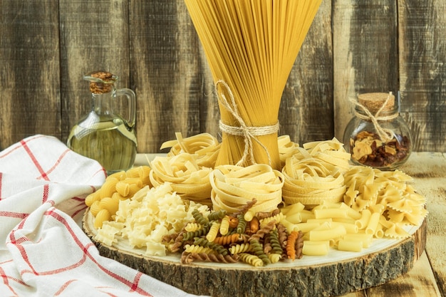 Assortment of dried pasta on a wooden background