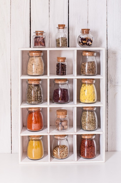 Assortment of dry spices in vintage glass bottles in wooden box