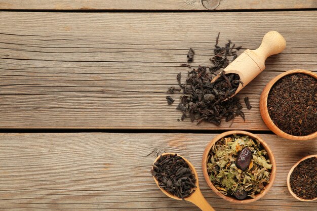 Assortment of dry tea on grey wooden background