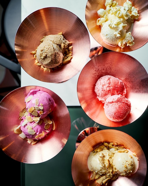 Assortment of flavored ice cream in copper bowls top view