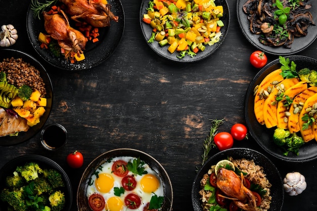 Assortment of food Salad avocado quail mushrooms pumpkin On a black background Top view Free space for your text