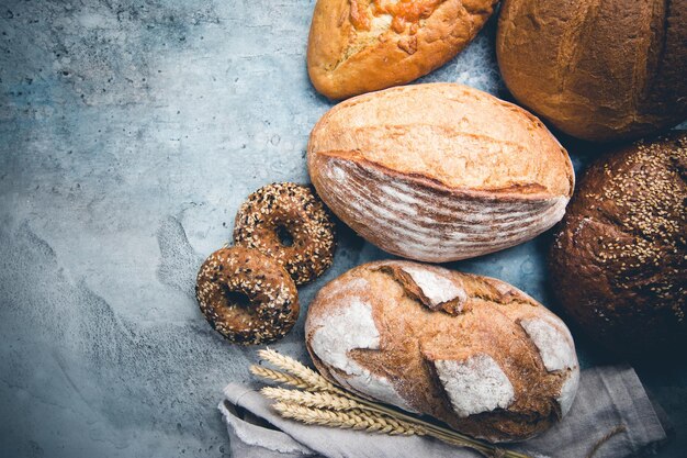 Assortimento di pane e focacce appena sfornate su sfondo di pietra, vista dall'alto