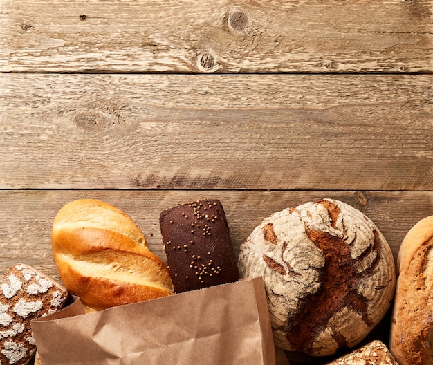 Assortment of fresh baked bread on a wooden background