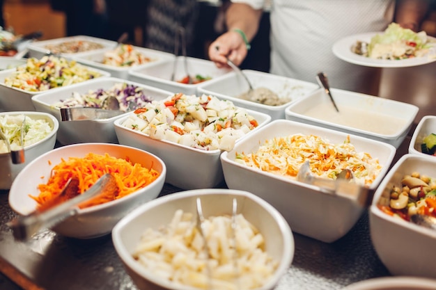 Foto assortimento di piatti freschi esposti nel buffet dell'hotel varietà di cibi in mensa pronti per la cena insalate di verdure tutto compreso